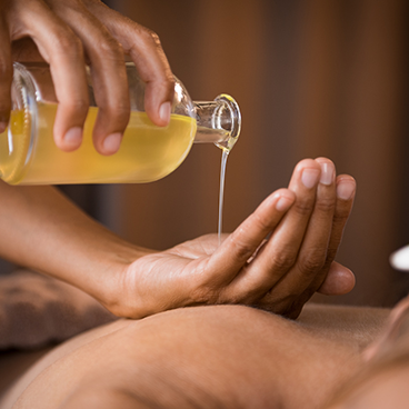 pouring oil for massage on hand rainbow spa Karachi